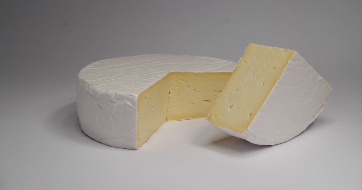KI generiert: Ein Laib weißer Weichkäse mit einem herausgeschnittenen Stück.